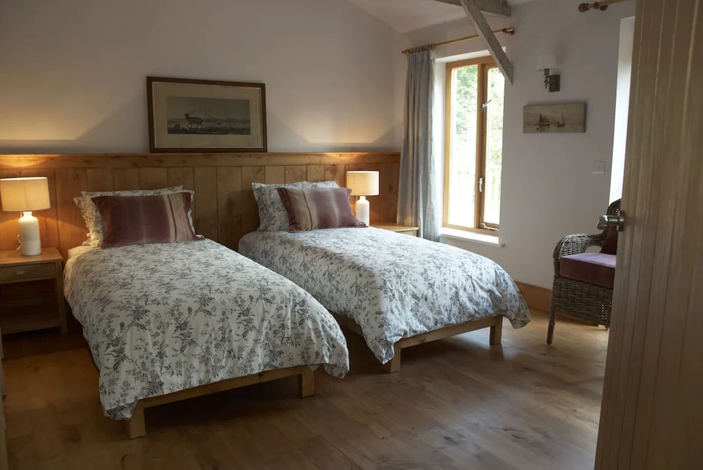 Pink bedroom arranged as twin beds, with option to convert to a king-size, and ensuite wet room